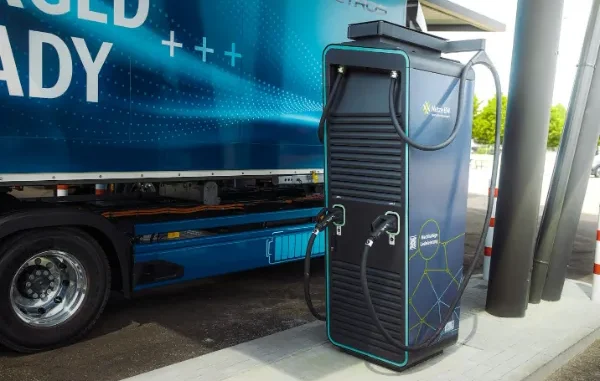 A blue truck at an electrical charging station
