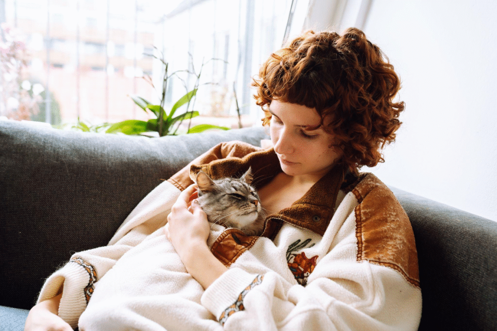 A young woman hugging an emotional support cat.